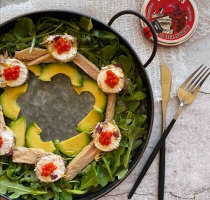 Ensalada circular con rúcula, bonito del norte, queso de cabra y perlas de tomate